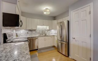 An updated kitchen with quartz countertops and stainless steel appliances.